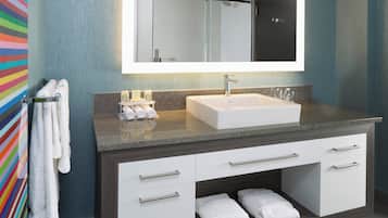 A modern bathroom with a white sink, a towel rack, and a mirror above the sink.
