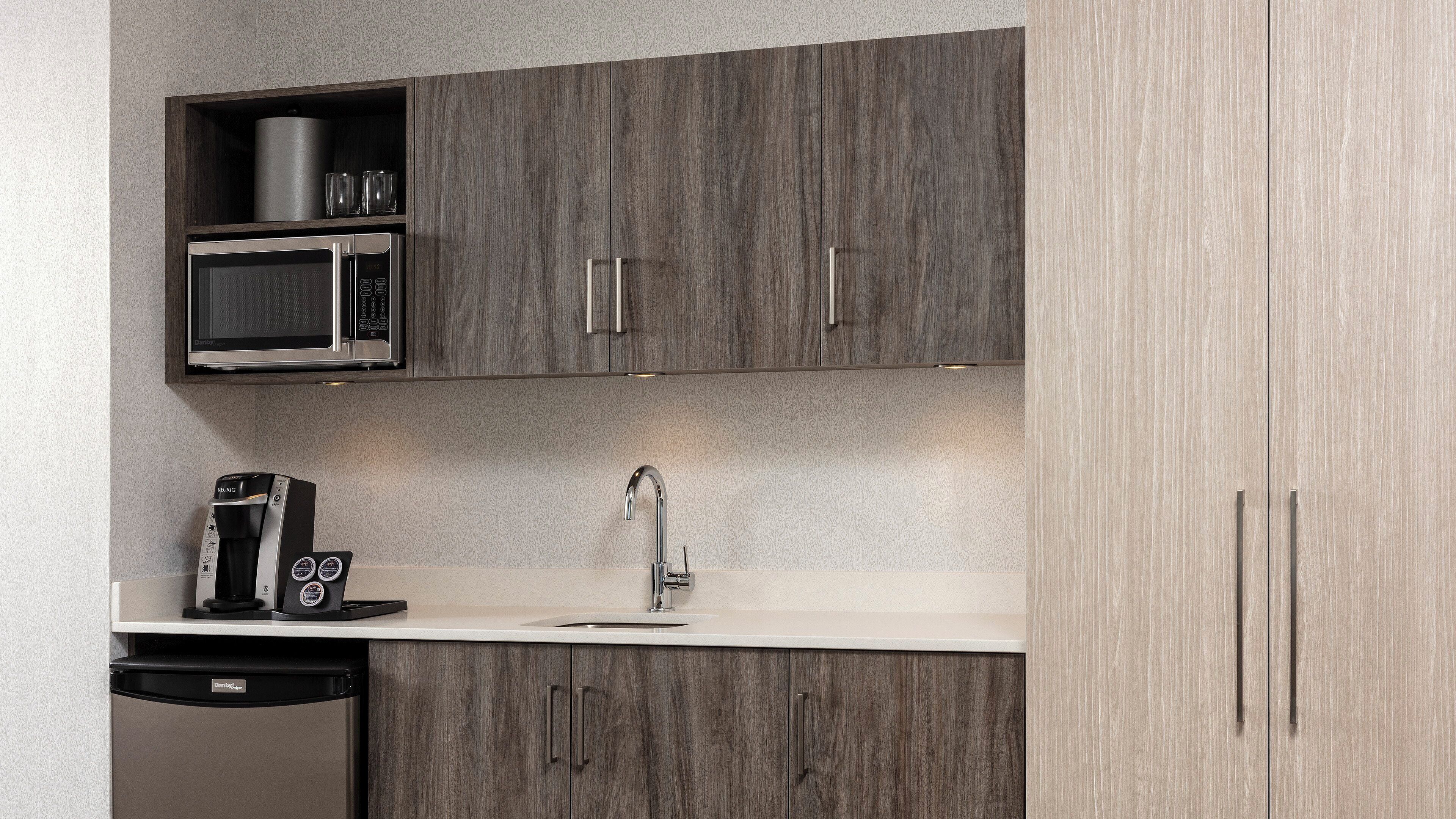 A modern kitchen with a built-in microwave, coffee machine, and dishwasher.
