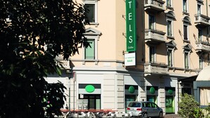 Een hotel met een opvallend groen bord, een bar en een fietsenstalling.