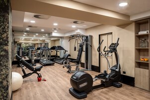 A gym with various exercise equipment, including treadmills, elliptical machines, and weight machines.