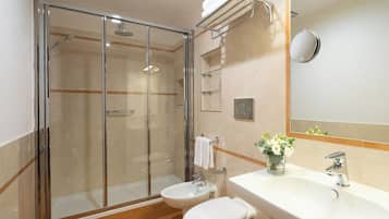 Een moderne badkamer met een douchecabine van glas, een wastafel en een toilet.