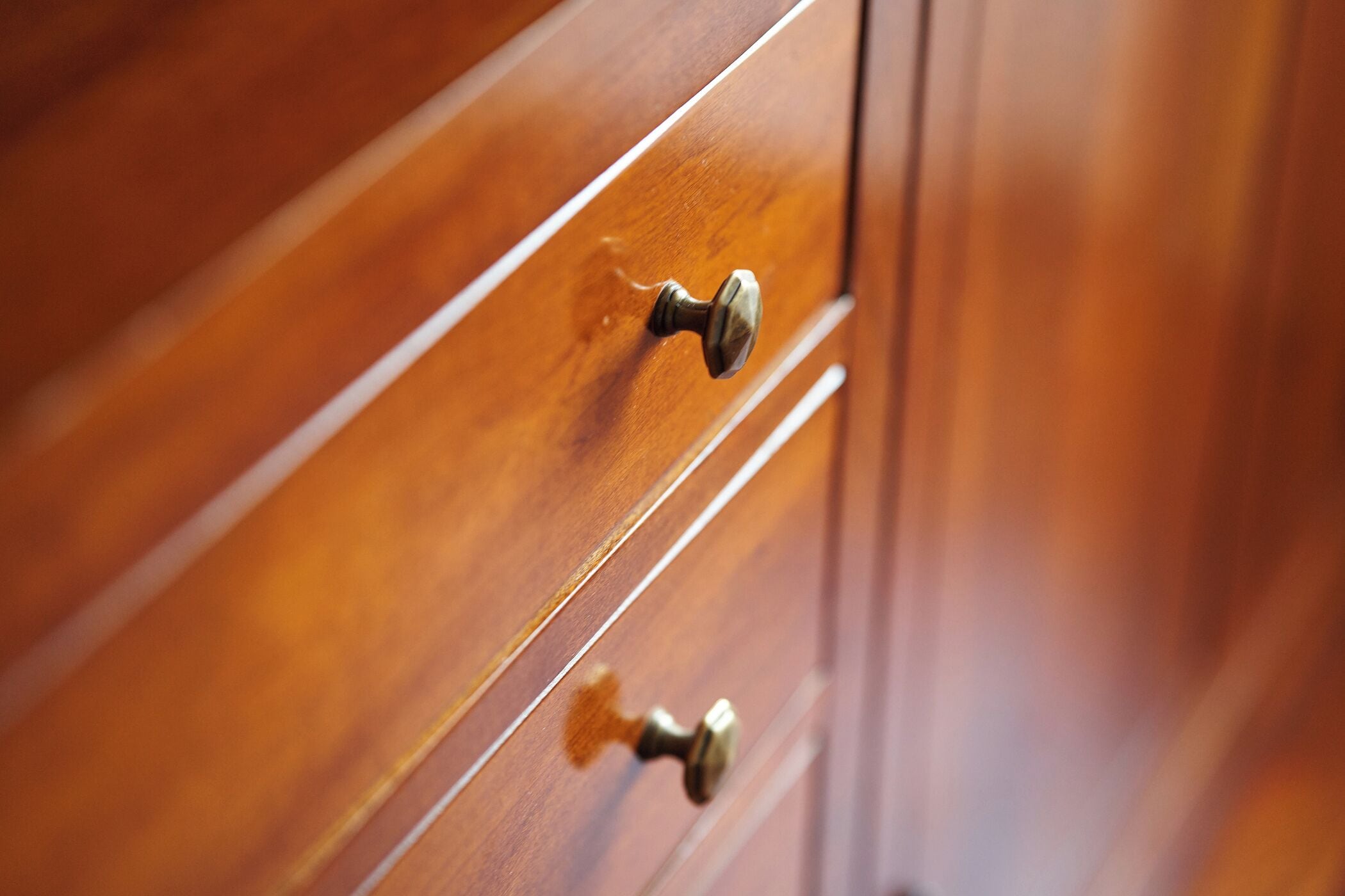 A wooden drawer with a brass handle.
