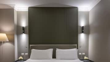 Een hotelkamer met een groot bed, twee nachtkastjes, een wandlamp en een vloerlamp.