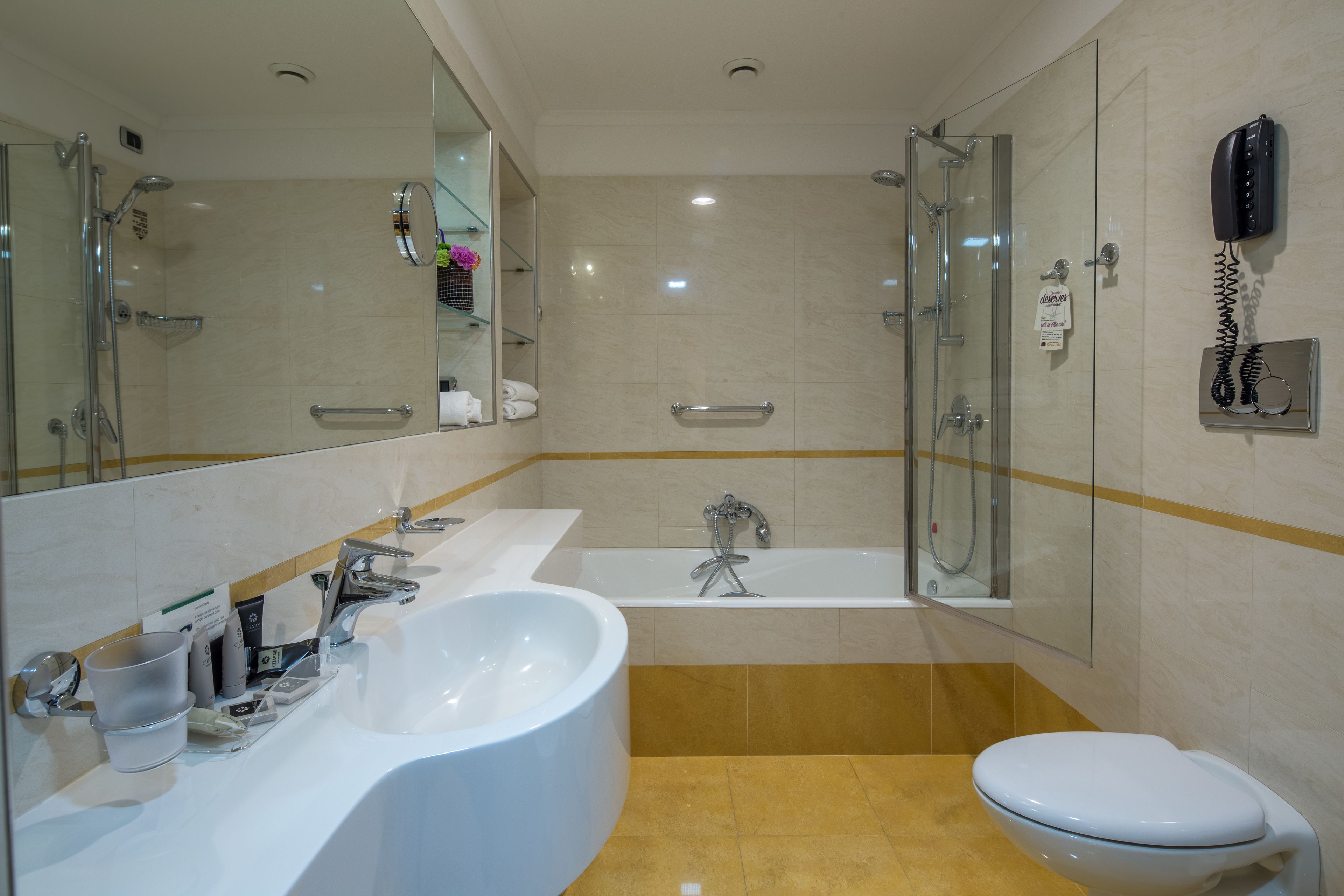 Un baño moderno con una bañera grande, una zona de ducha independiente, un inodoro y un lavabo con espejo.