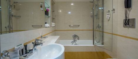 Un baño moderno con una bañera grande, una zona de ducha independiente, un inodoro y un lavabo con espejo.