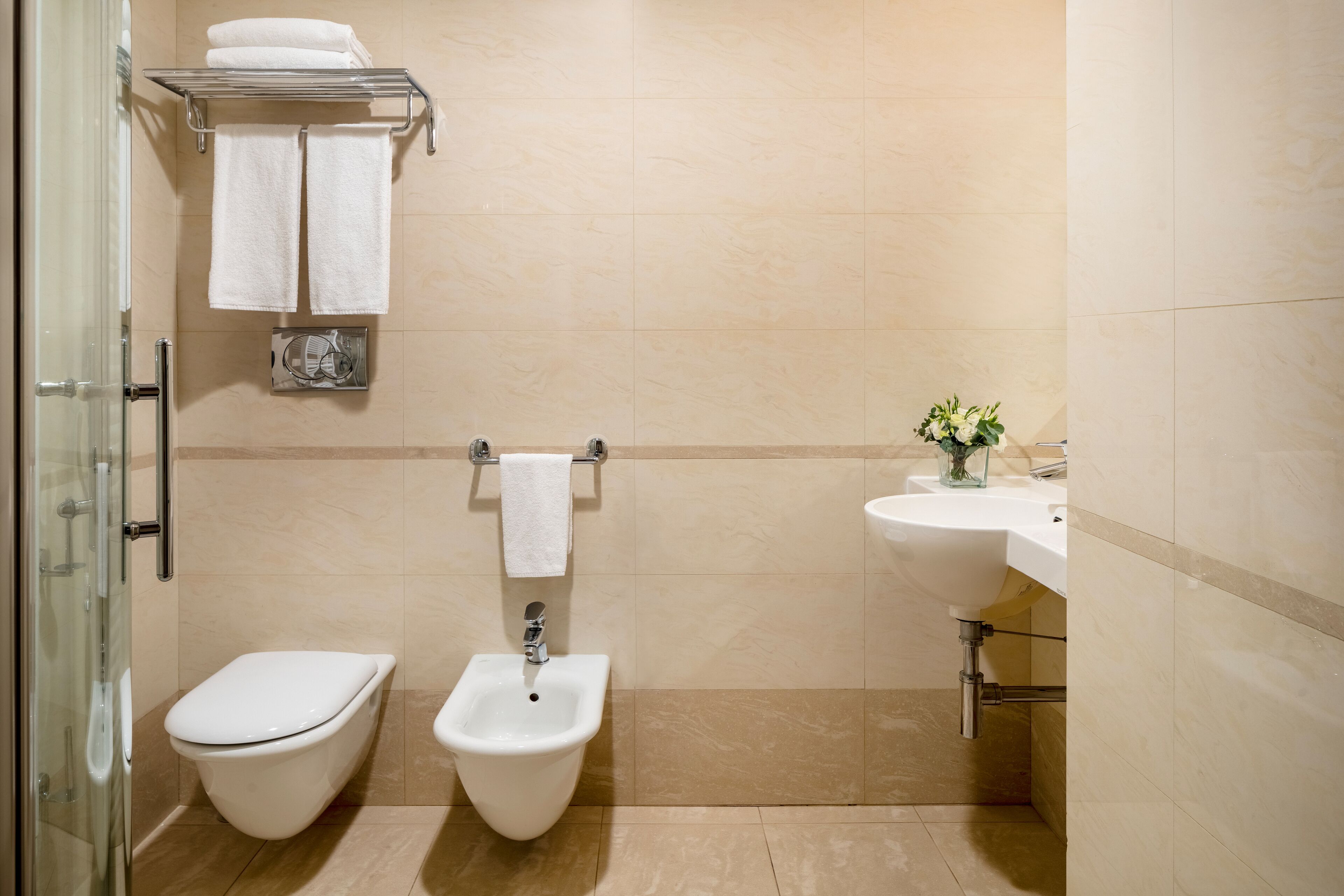 A modern bathroom with a toilet, bidet, and sink.