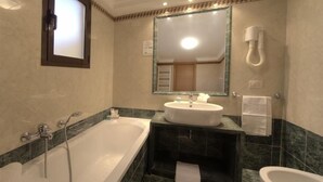 A modern bathroom with a large bathtub, a sink, and a toilet. - Galileo (Rome)