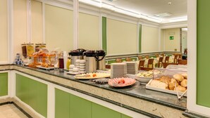 A buffet area with various food items and beverages, including plates of food, bowls, and containers. - Hotel Igea (Rome)