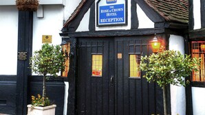 A traditional Tudor-style building with a reception sign for the Rose & Crown Hotel.
