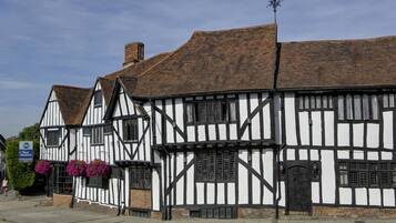 A traditional half-timbered building with a black and white facade, a visible chimney, and a door with a small window.