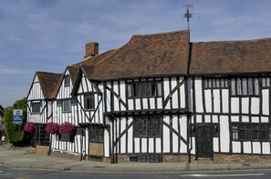 A traditional half-timbered building with a black and white facade, a visible chimney, and a door with a small window. - Best Western The Rose & Crown Hotel (Colchester)
