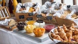 A breakfast buffet with various fruits, yogurts, and pastries.