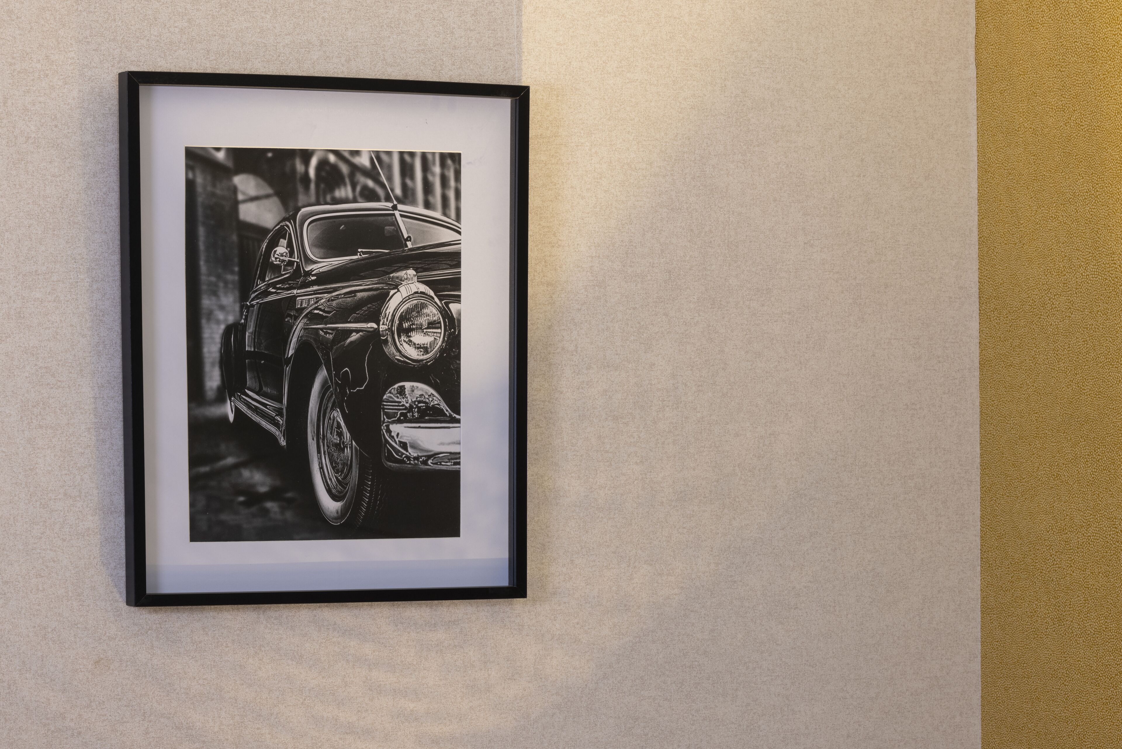 A framed black and white photograph of a vintage car.