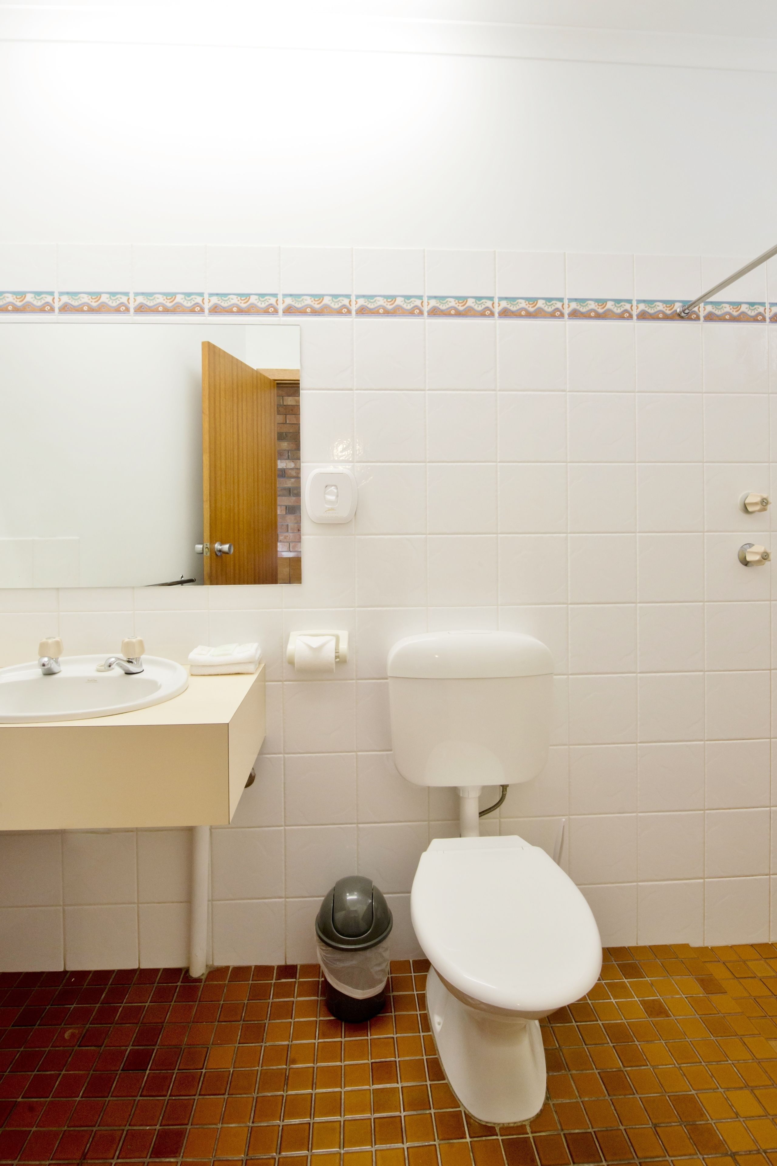 Ein Badezimmer mit Waschbecken, Spiegel und Toilette.