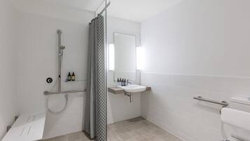 A modern bathroom with a shower, toilet, and sink.