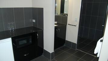 A modern bathroom with a black countertop, a sink, and a mirror.