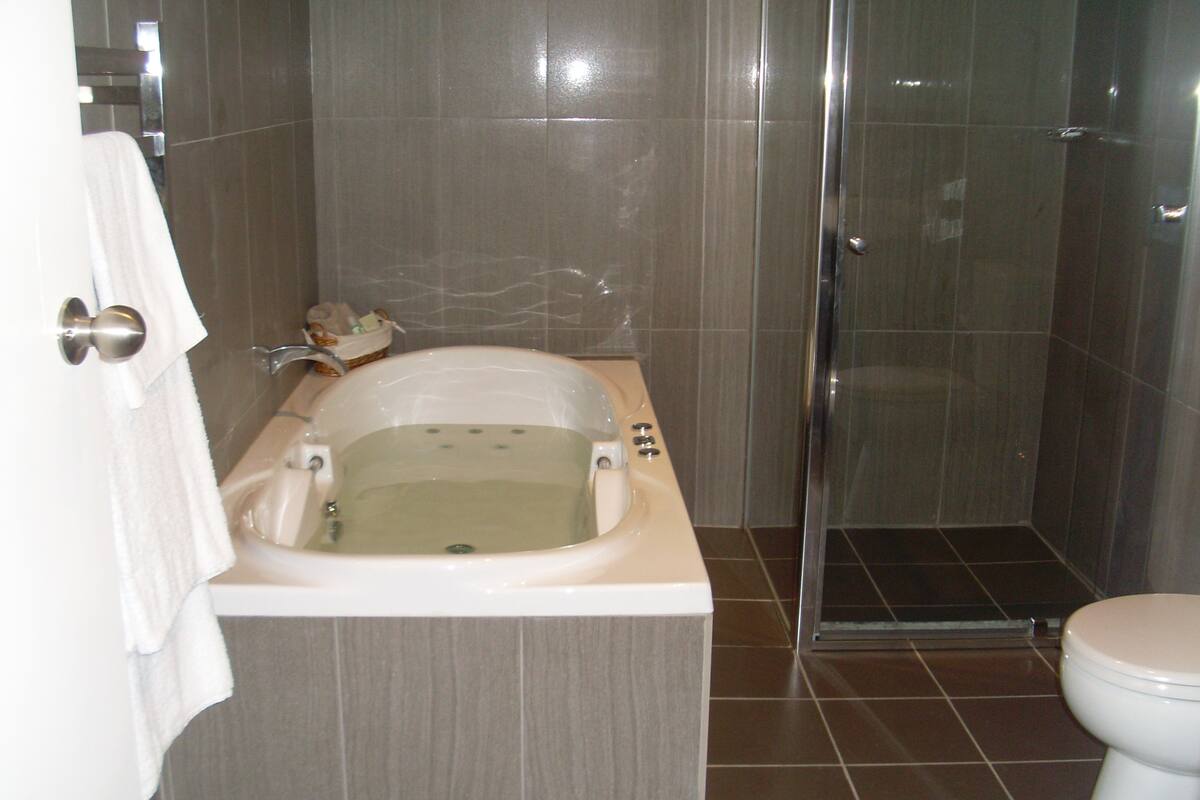 A bathroom with a bathtub, toilet, and shower.