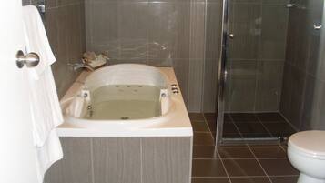 Un baño con bañera, inodoro y ducha.