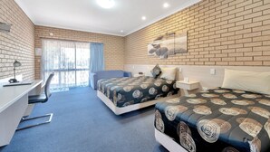 Une chambre d’hôtel avec deux lits, un bureau et une chaise.