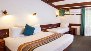 A hotel room with two beds, wooden headboards, white bedding, and a striped throw blanket. - Blackheath Motor Inn (Blackheath)