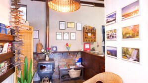 A cozy interior with a fireplace, wooden shelves, and framed pictures on the walls. - Blackheath Motor Inn (Blackheath)