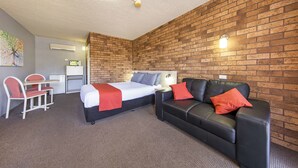 A hotel room with a bed, a sofa, a desk, and a chair. - Comfort Inn Dubbo City (Dubbo)