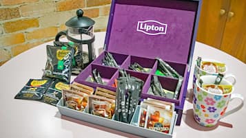 Un set de regalo de café que incluye té Lipton, cápsulas de café variadas y una taza con motivos florales.