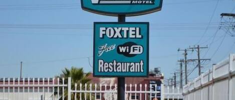 A sign for SPA VILLAGE MOTEL and FOXTEL for WiFi Restaurant.