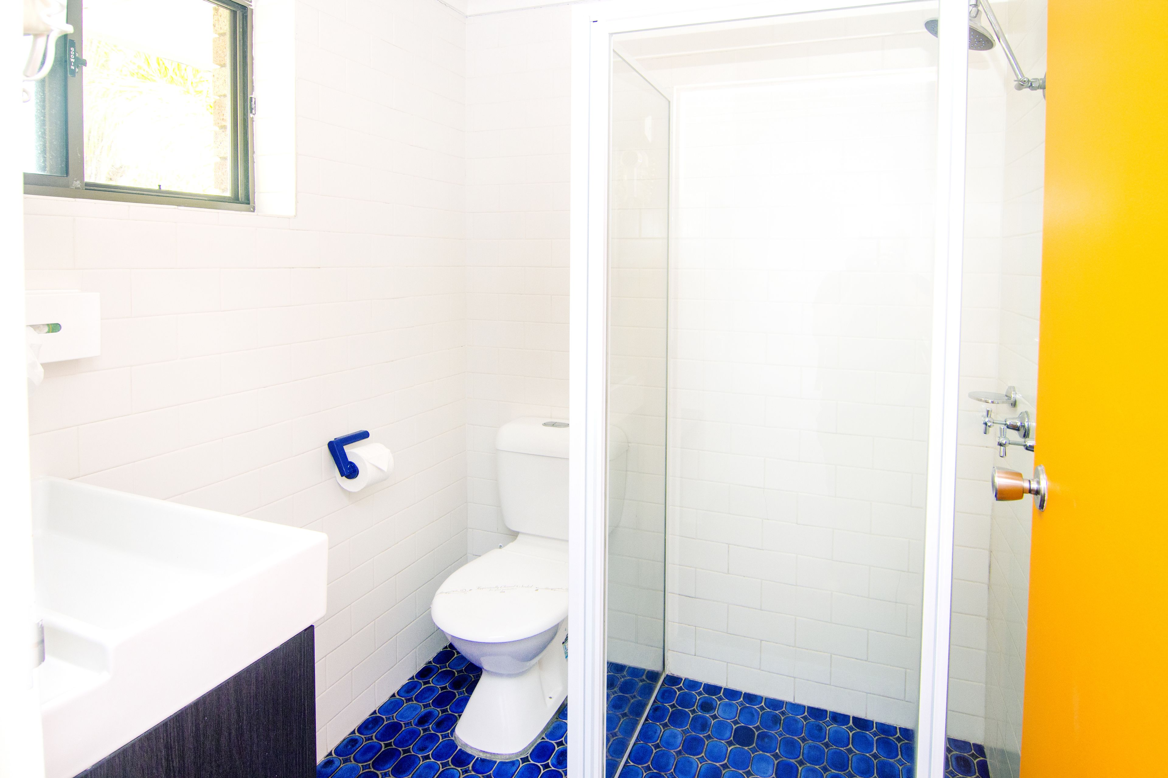 A bathroom with a white toilet, a white bathtub, and a glass-enclosed shower.