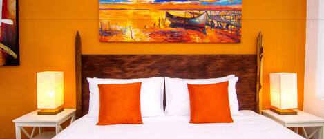 A hotel room with a large bed, two nightstands, two lamps, and a painting on the wall.