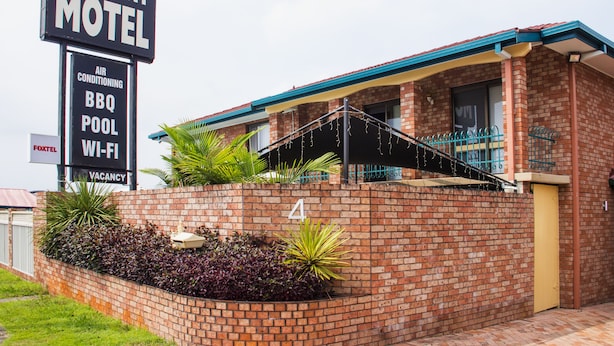 A brick motel with a signboard advertising amenities like air conditioning, BBQ, pool, and Wi-Fi. - Crescent Motel (Taree)