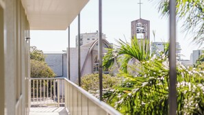 A balcony with a view of a church steeple and surrounding buildings. - The Heritage Darwin (Darwin)