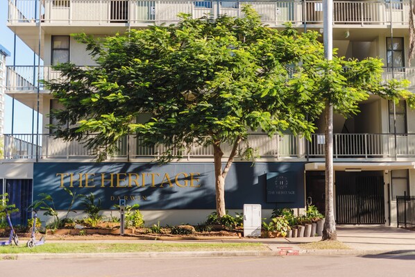 A multi-story building with balconies and a sign that reads "THE HERITAGE DARWIN".