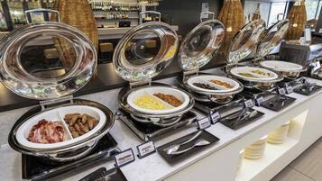 A buffet with various food options, including bacon, scrambled eggs, and other dishes.