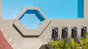 A swimming pool with a hexagonal section, lounge chairs, and a tiled deck. - Mercure Rockhampton (Rockhampton)