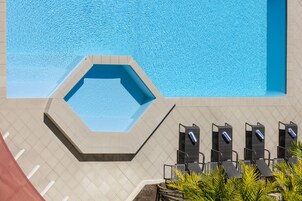 Una piscina al aire libre, sillones reclinables de piscina