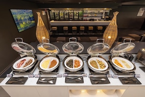 A buffet with labeled food sections, a bar area, and a seating area with chairs. - Mercure Rockhampton (Rockhampton)