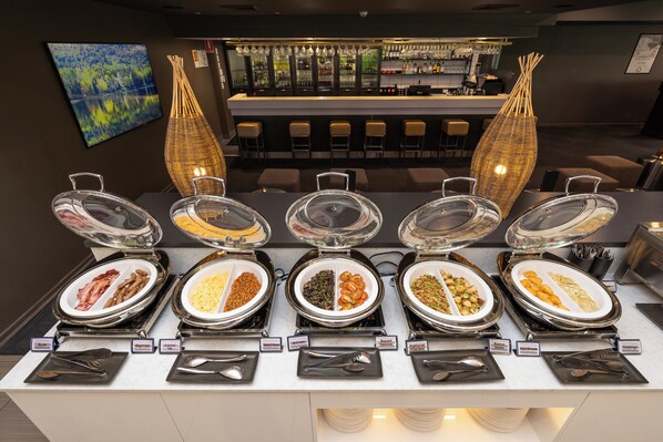 A buffet with labeled food sections, a bar area, and a seating area with chairs. - Mercure Rockhampton (Rockhampton)