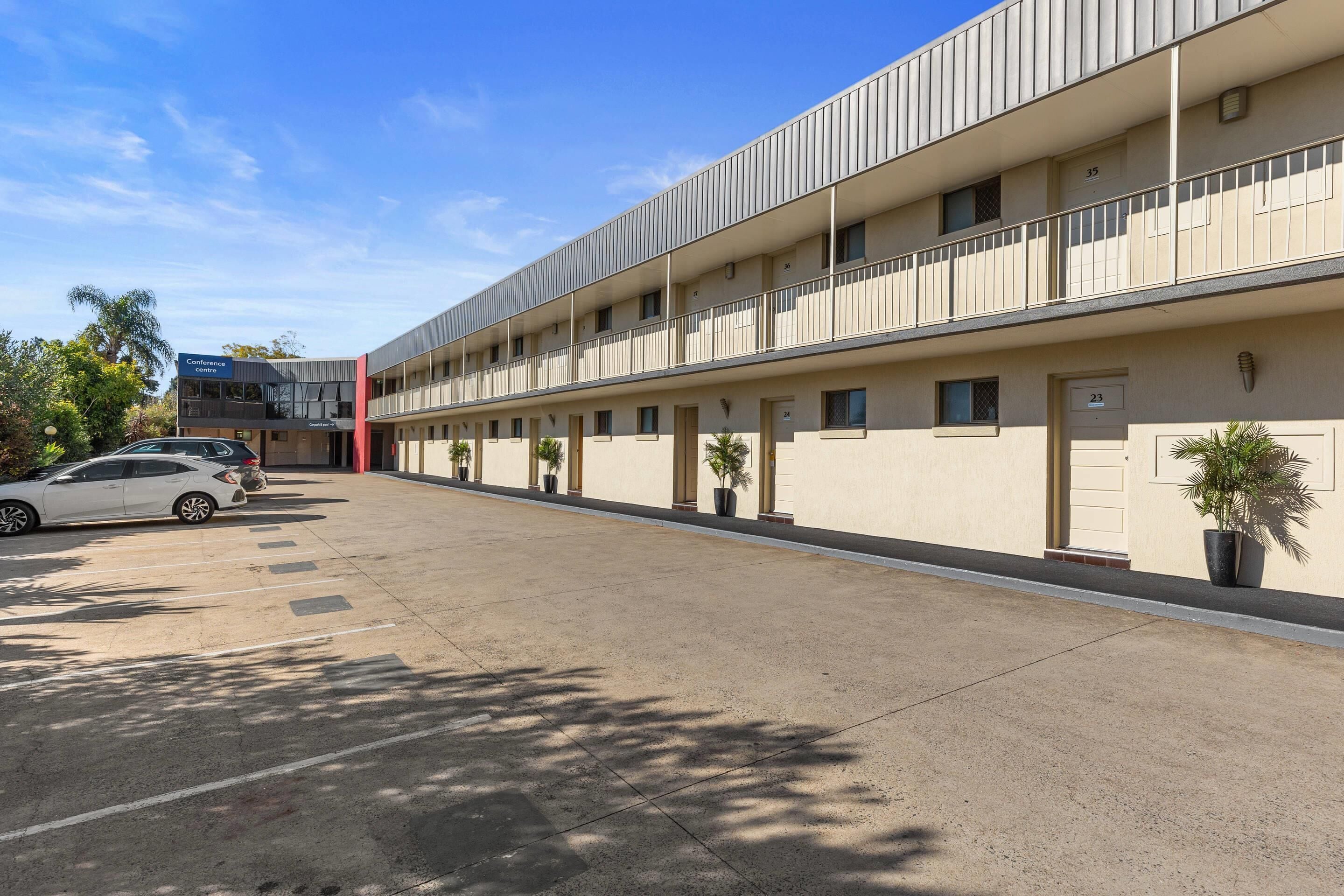 Ein mehrstöckiges Hotel mit modernem Design, ausgestattet mit Balkonen und Topfpflanzen.