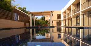 A modern building with a pool area, wooden pergola, and glass balconies. - Comfort Inn Grammar View (East Toowoomba)