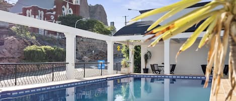 Una piscina al aire libre, tumbonas