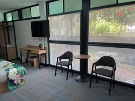 Escritorio, cortinas blackout y tabla de planchar con plancha 