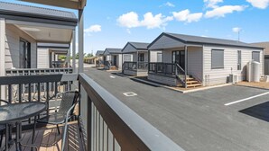 A row of mobile homes with a covered outdoor area, each with a small porch and steps leading to the entrance. - Comfort Inn & Suites Manhattan (Enfield)