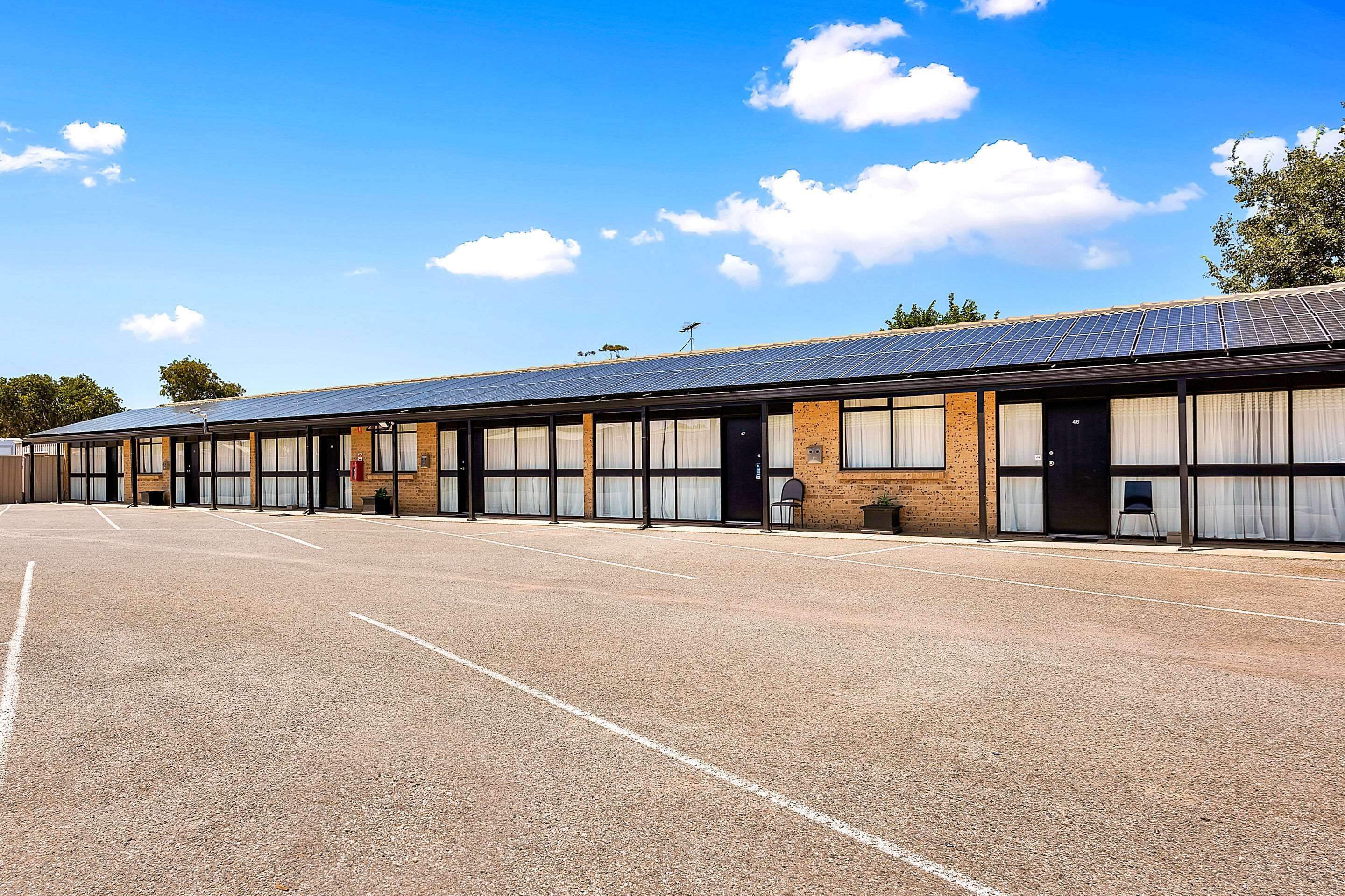 A row of single-story buildings with large windows and a flat roof, likely a motel or hotel.