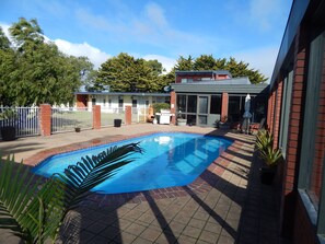 Una piscina al aire libre, sombrillas