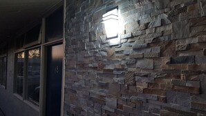 Eine Gebäudefassade mit einer Steinwand und einer Tür mit der Aufschrift '18'.