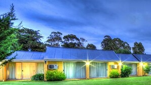 A two-story motel with a blue roof, large windows, and a well-maintained lawn. - Bairnsdale Motor Inn (Bairnsdale)