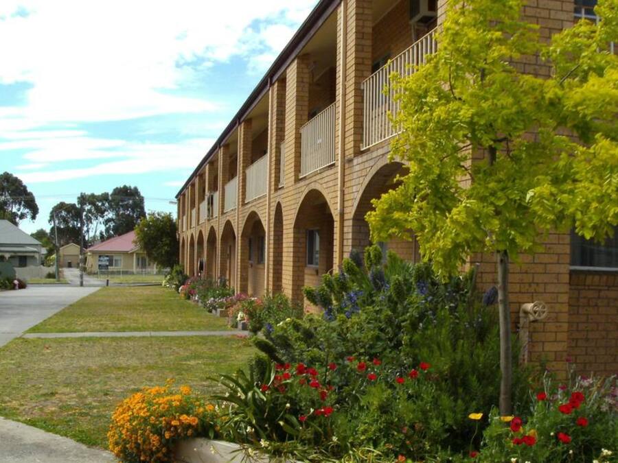 Un edificio de ladrillo con ventanas de arco y un balcón.