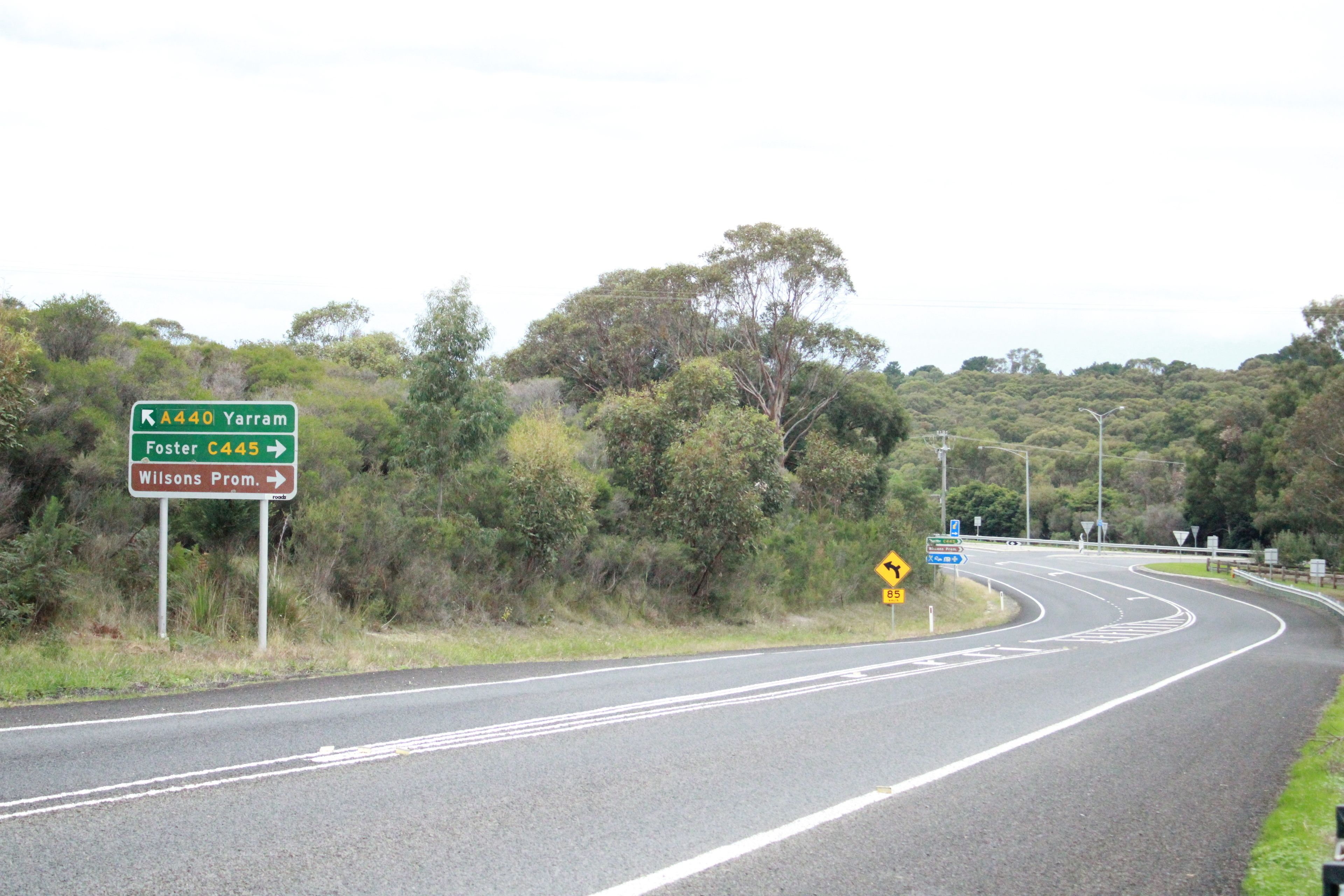 A road with directional signs for Yarram, Foster, and Wilsons Prom.