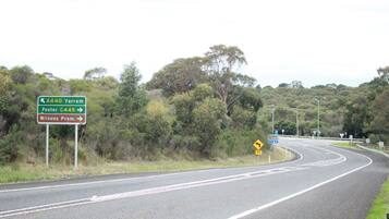 A road with directional signs for Yarram, Foster, and Wilsons Prom.